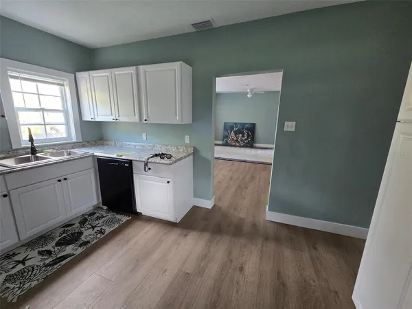 a kitchen with a cabinets and wooden floor