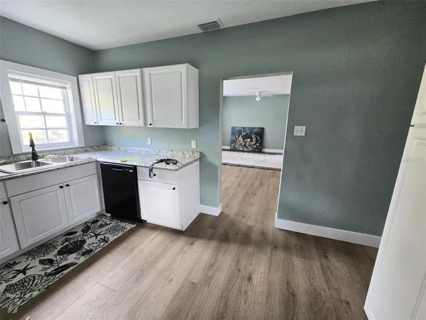 a kitchen with a wooden floor and white appliances
