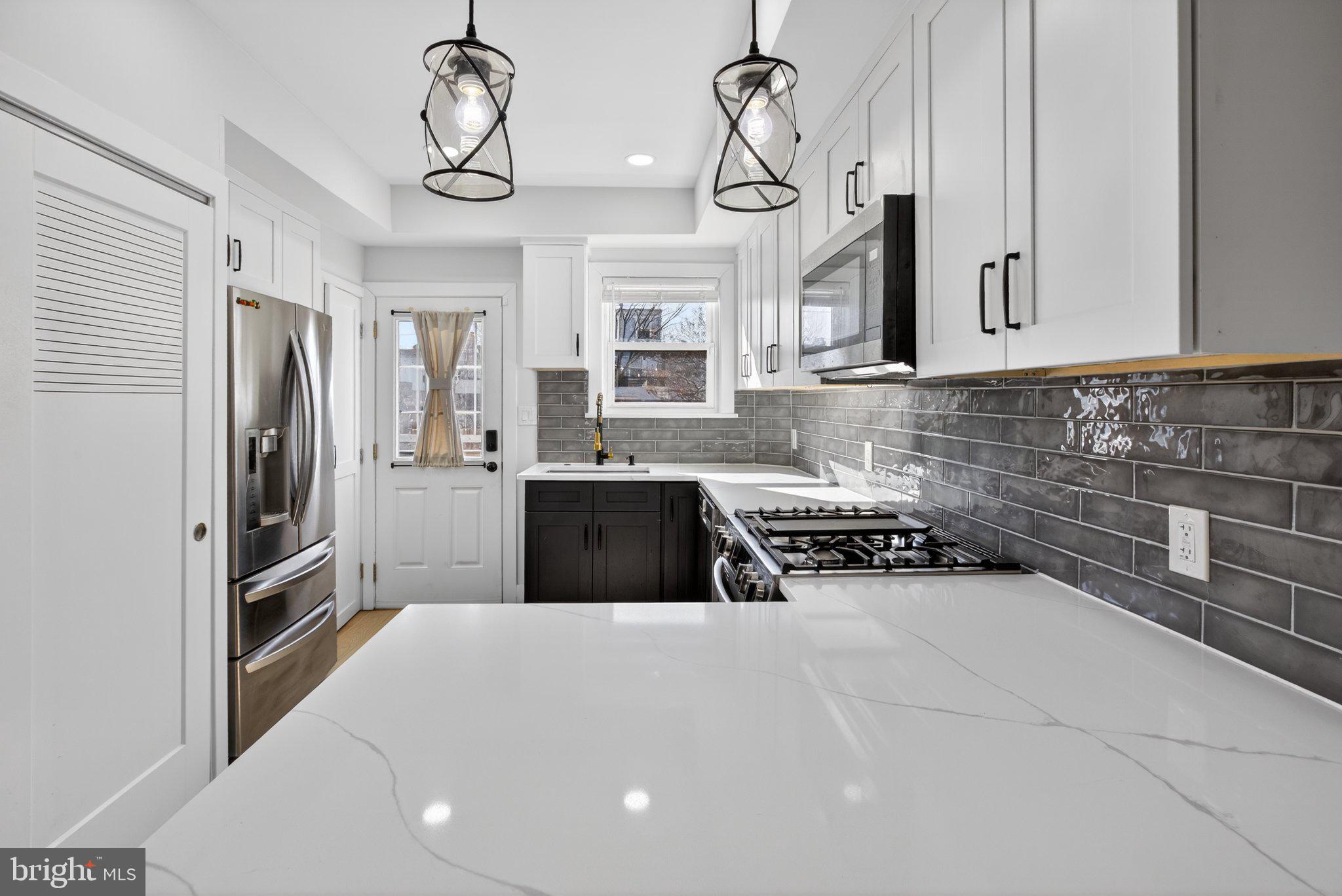 2015 Gales Street Northeast Washington, DC 20002 - Photo 4 of 10 a kitchen with stainless steel appliances a sink a stove a refrigerator cabinets and a window
