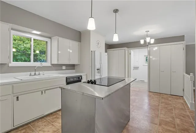 a kitchen that has a sink a window and stainless steel appliances