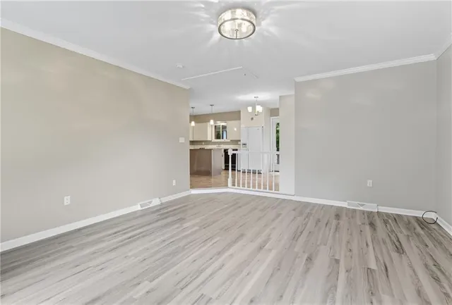 a view of a room with wooden floor and a ceiling fan