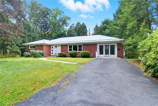 a front view of house with yard and green space