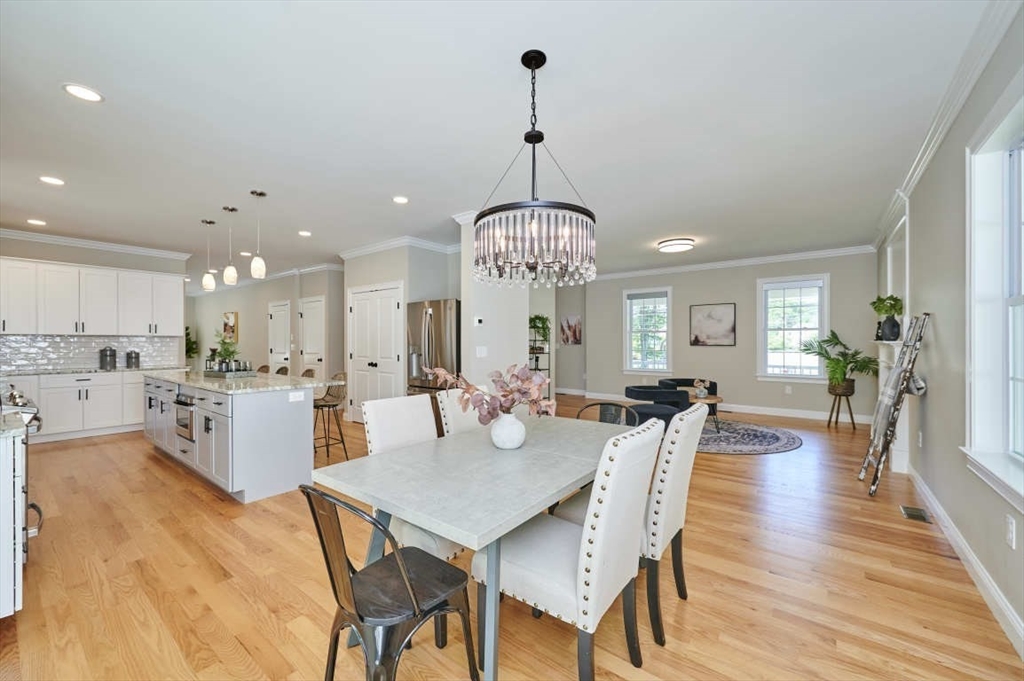 60 Peach Orchard Road Burlington, MA 01803 - Photo 12 of 42 a view of a dining room and livingroom with furniture wooden floor a rug a chandelier