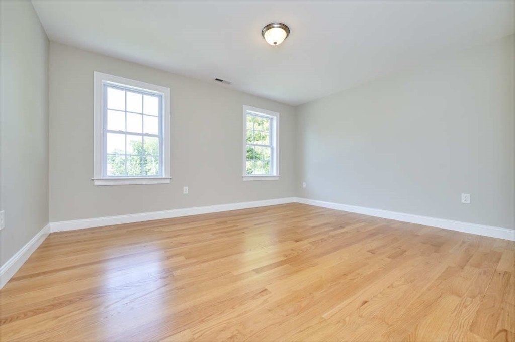 60 Peach Orchard Road Burlington, MA 01803 - Photo 23 of 42 an empty room with wooden floor and windows