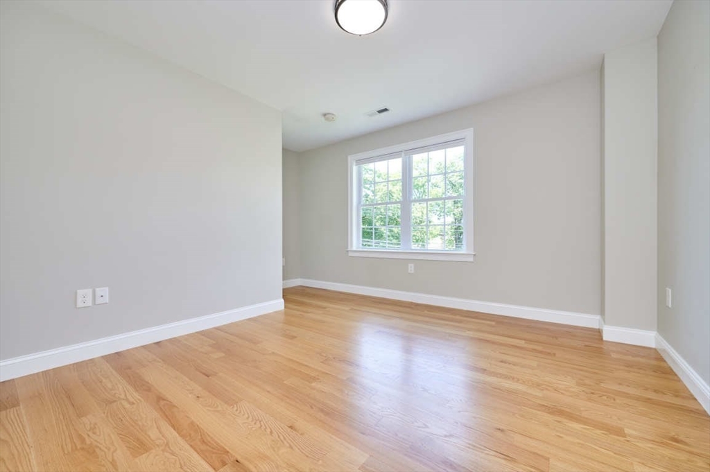 60 Peach Orchard Road Burlington, MA 01803 - Photo 27 of 42 an empty room with wooden floor and windows