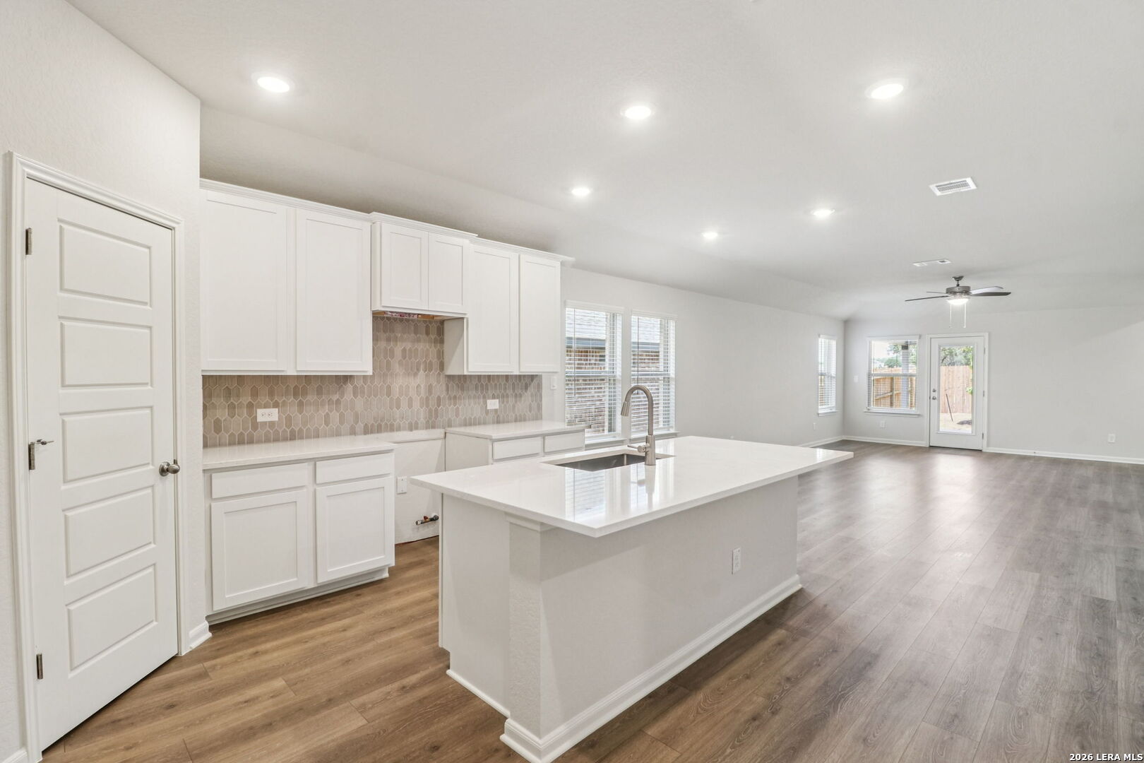 9909 Paladin Ridge San Antonio, TX 78254 - Photo 14 of 41 a large white kitchen with wooden floors and white cabinets