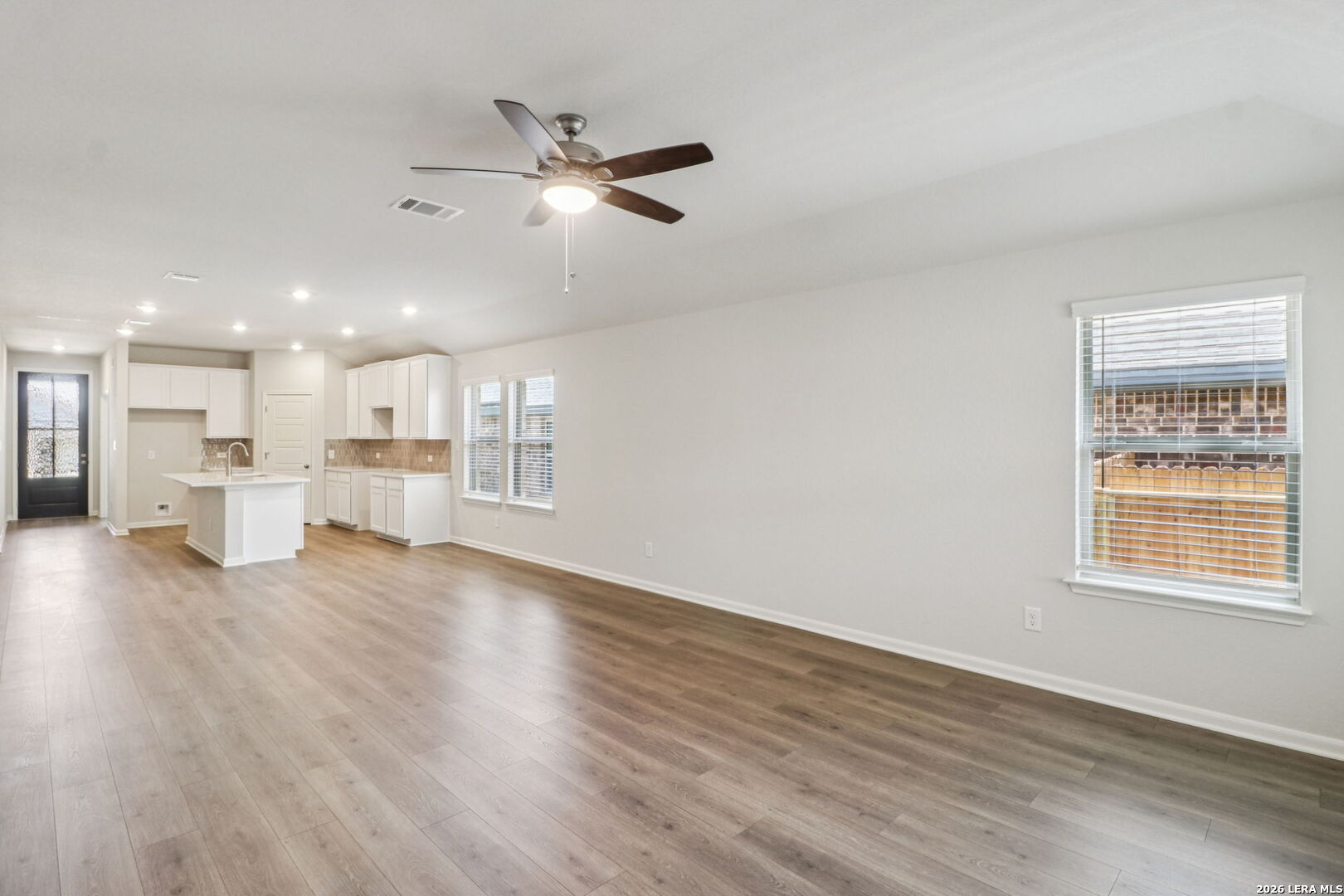 9909 Paladin Ridge San Antonio, TX 78254 - Photo 10 of 41 a view of an empty room with wooden floor and a window