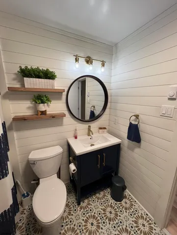 a bathroom with a toilet a sink and mirror