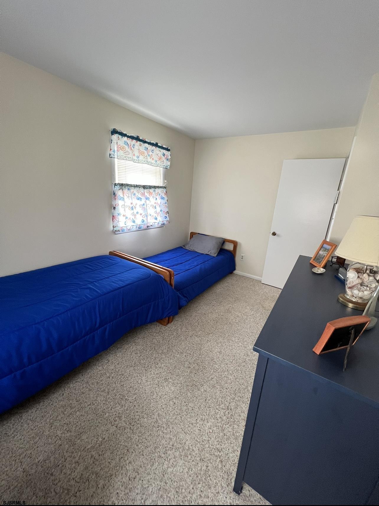 215 2nd Street North, Unit 1 Brigantine, NJ 08203 - Photo 17 of 24 a bedroom with a bed and window