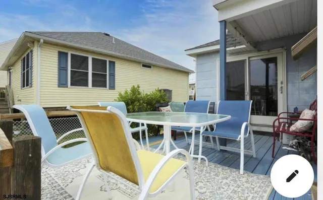 a view of a patio with table and chairs with wooden floor and fence