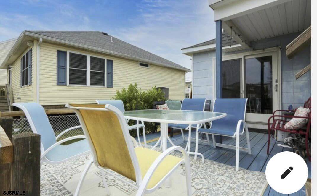 215 2nd Street North, Unit 1 Brigantine, NJ 08203 - Photo 20 of 24 a view of a patio with table and chairs with wooden floor and fence