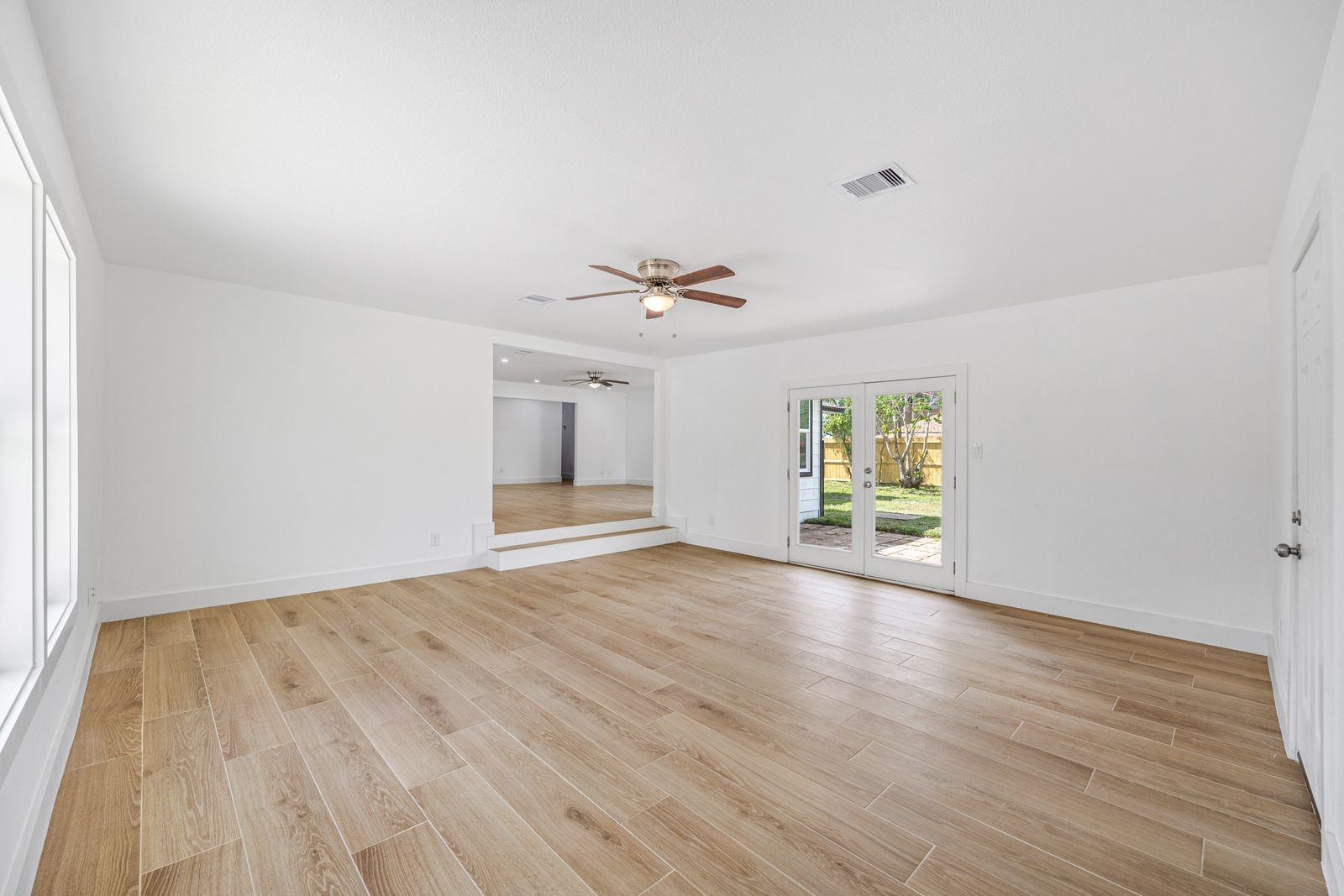 1214 Main Street Alvin, TX 77511 - Photo 9 of 26 wooden floor in an empty room with a window