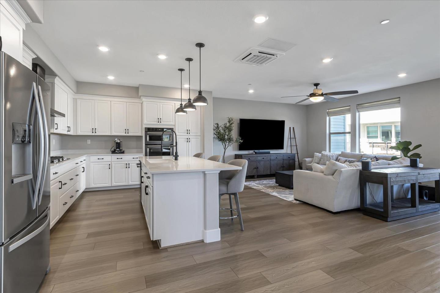 6823 Vector Court San Jose, CA 95119 - Photo 11 of 51 a kitchen with stainless steel appliances kitchen island granite countertop a stove top oven a sink dishwasher a refrigerator and white cabinets with wooden floor