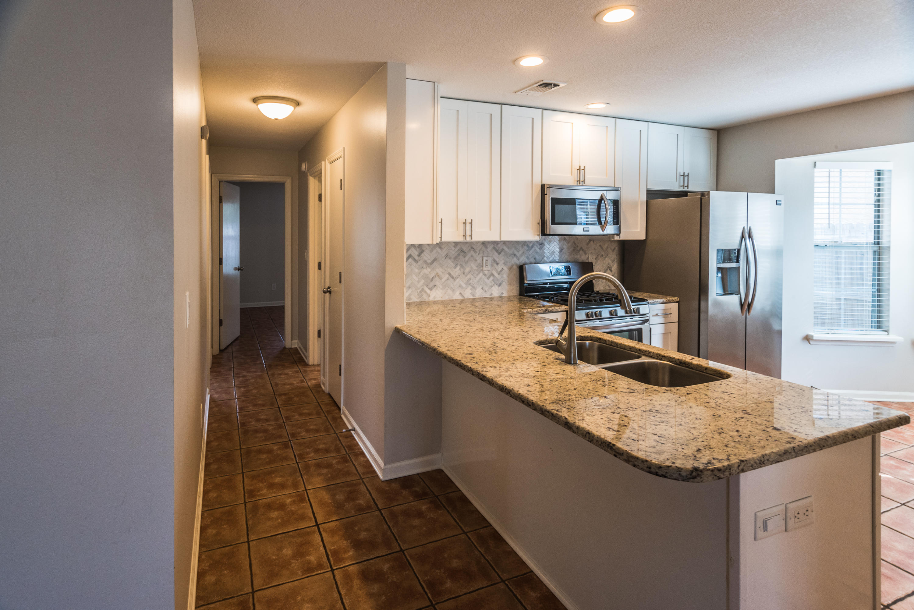 52 Rue D Honfleur Destin, FL 32541 - Photo 7 of 22 a kitchen with granite countertop stainless steel appliances a sink stove refrigerator and cabinets