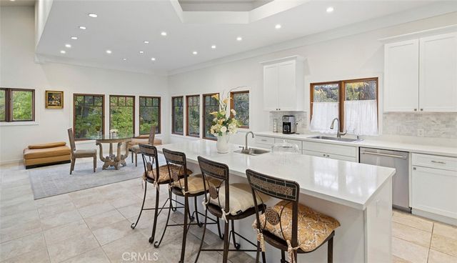 a kitchen with a dining table chairs and white cabinets