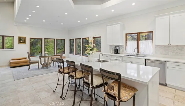 a kitchen with a dining table chairs and white cabinets