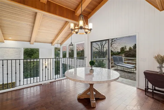 a dining room with wooden floor and furniture