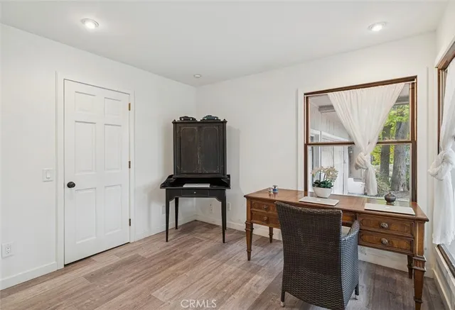 a view of a workspace with furniture and a window