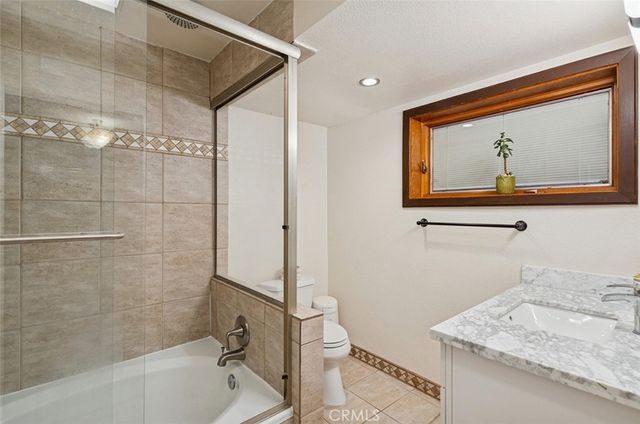 a bathroom with a granite countertop sink mirror toilet and bathtub