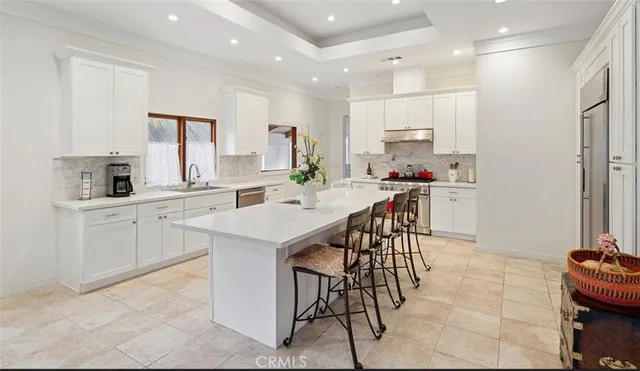 a kitchen with stainless steel appliances kitchen island granite countertop a sink and cabinets