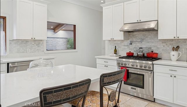 a kitchen with stainless steel appliances a stove a sink cabinets and a refrigerator