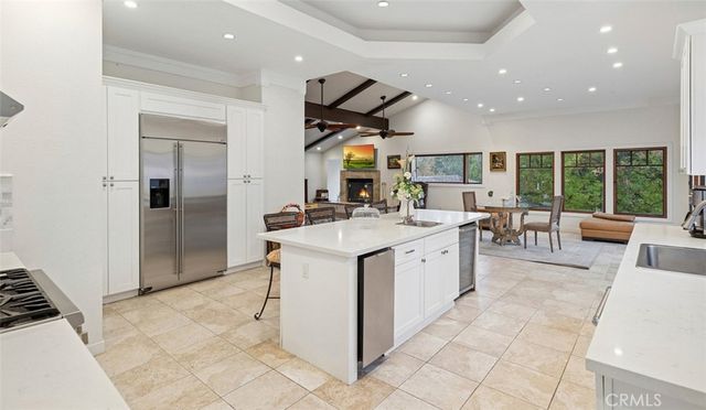 a large white kitchen with a large window and stainless steel appliances