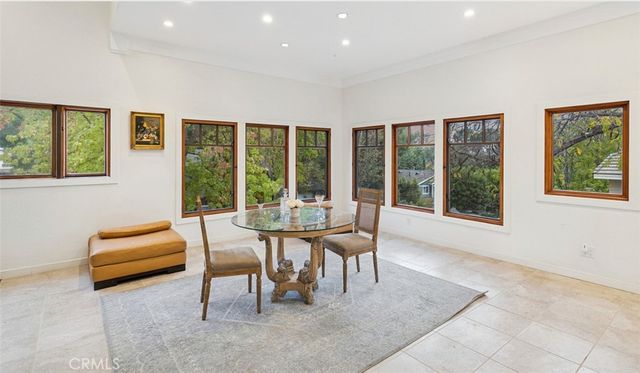 a dining room with wooden floor and glass windows