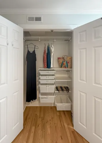 a view of walk in closet with clothes and shoes