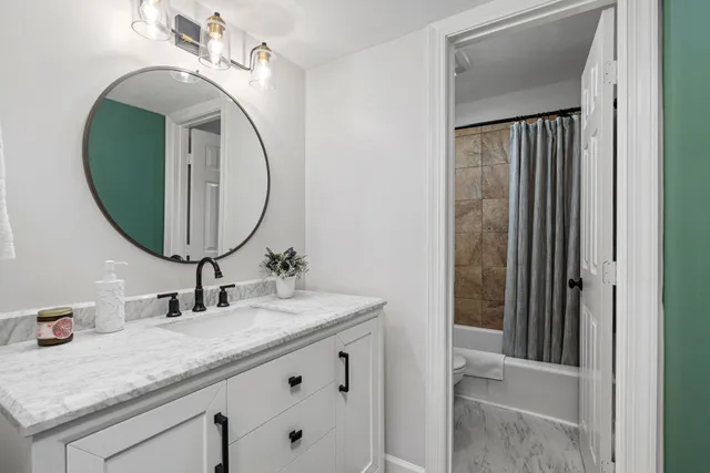 a bathroom with a granite countertop sink and a mirror