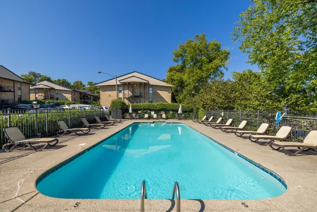 a view of a swimming pool with a patio and a garden