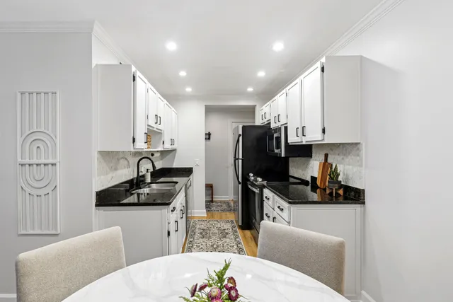 a kitchen with stainless steel appliances a sink a stove a refrigerator a window