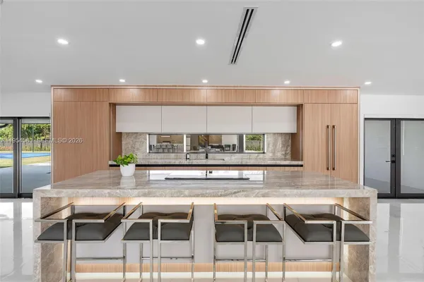 a hallway with cabinets and a refrigerator