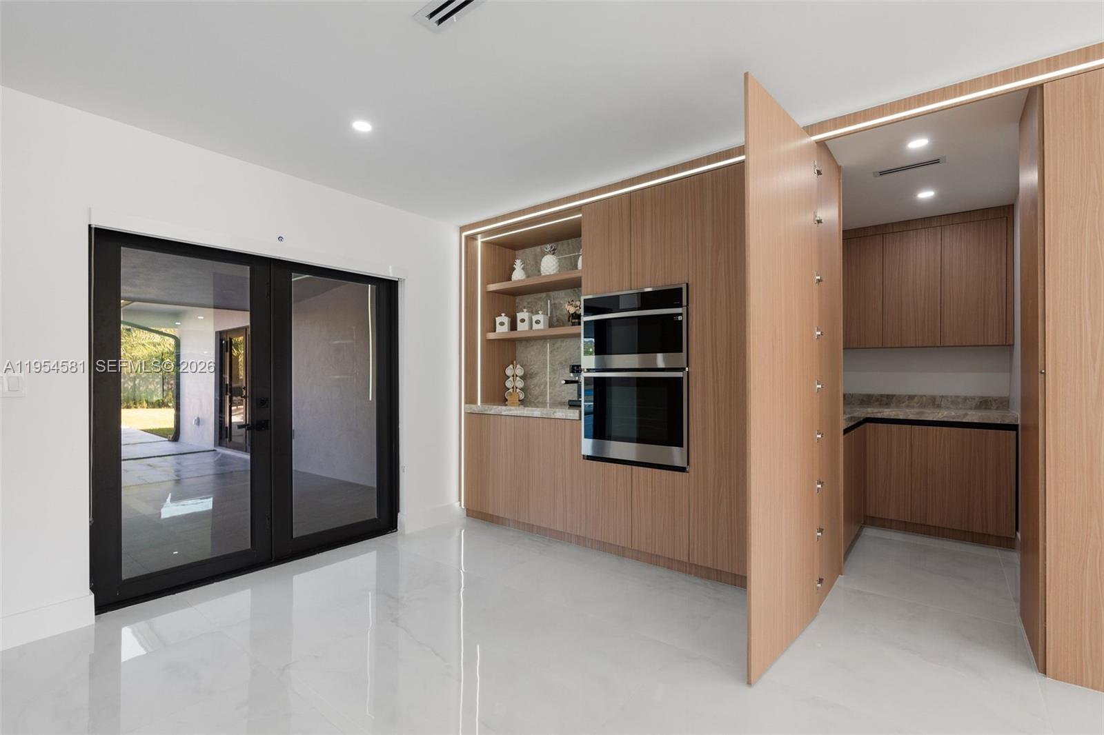 12425 Southwest 226th Street Miami, FL 33170 - Photo 20 of 75 a hallway with cabinets and a refrigerator