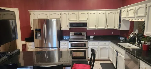 a kitchen with stainless steel appliances a refrigerator and a stove top oven