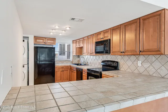 a kitchen with stainless steel appliances granite countertop a refrigerator and a stove top oven