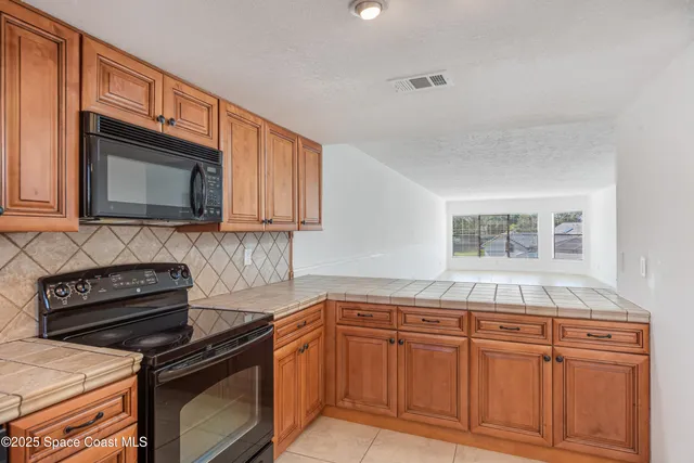 a kitchen with granite countertop cabinets stainless steel appliances and a sink