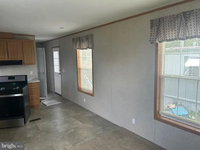 a view of a kitchen with an empty room and a window
