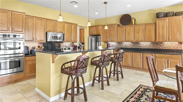 a kitchen with stainless steel appliances granite countertop a stove and a granite counter tops with white cabinets