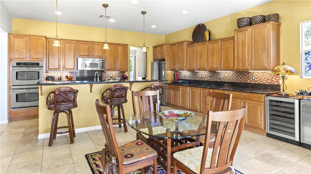 923 Union Street Cherry Valley, CA 92223 - Photo 13 of 68 a kitchen with stainless steel appliances granite countertop a kitchen island a stove a dining table and chairs