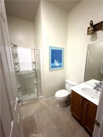 a living room with furniture a flat screen tv and a refrigerator