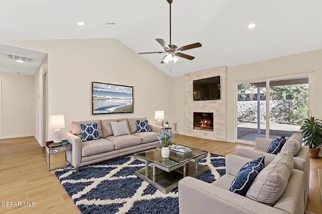 a living room with furniture a flat screen tv and a fireplace