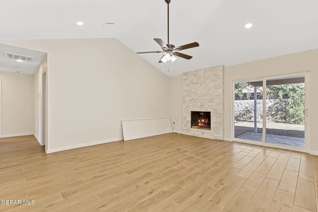 a view of empty room with wooden floor and ceiling fan