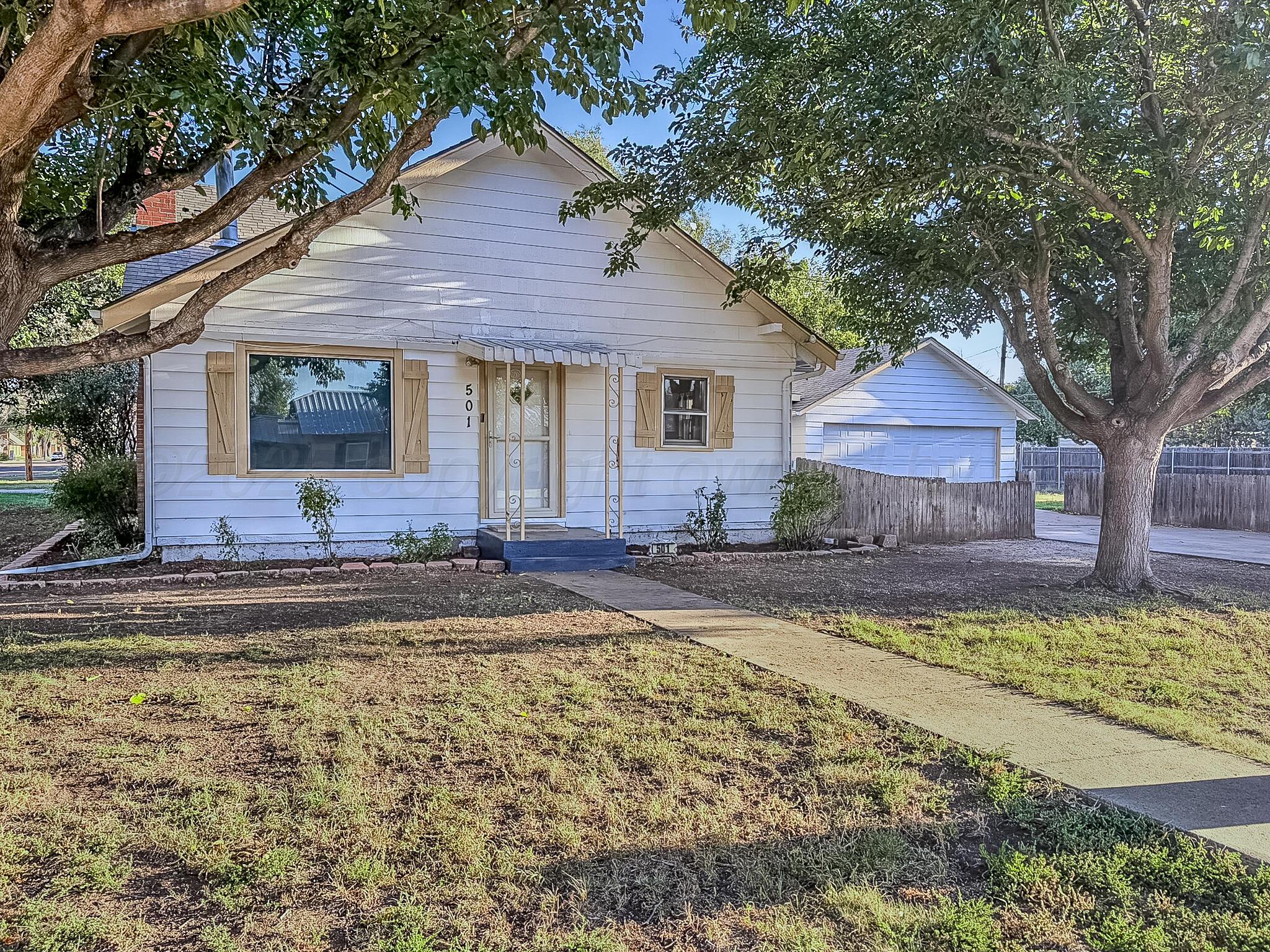 a front view of a house with swimming pool table and chairs