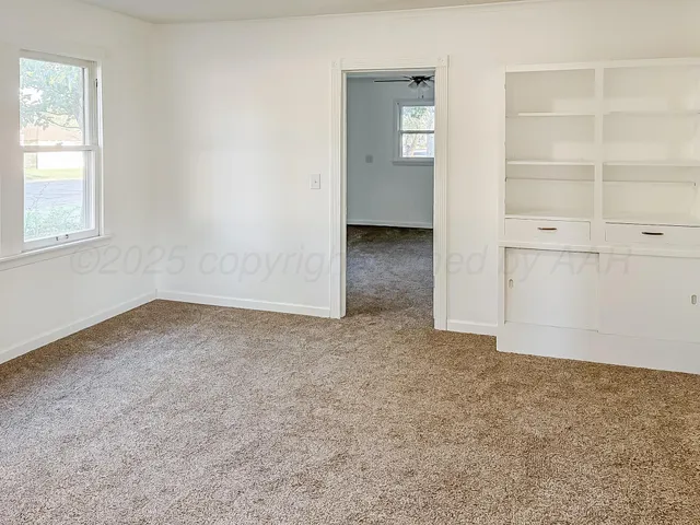 an empty room with closet and windows