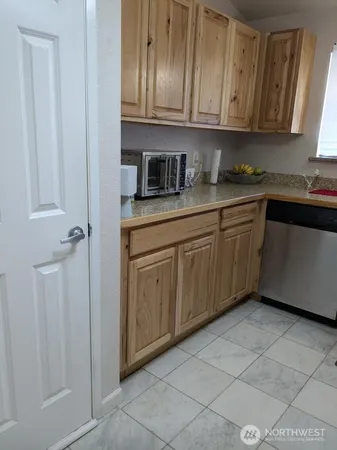 a kitchen with stainless steel appliances granite countertop a sink and dishwasher with white cabinets