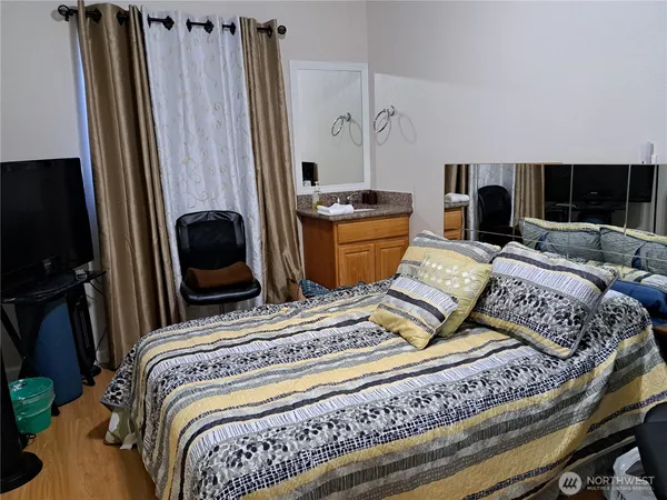 a bedroom with a bed and a flat tv screen