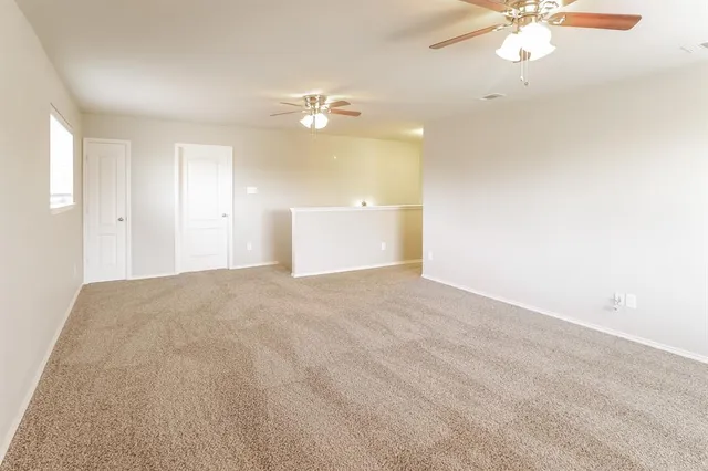 a view of empty room with a ceiling fan