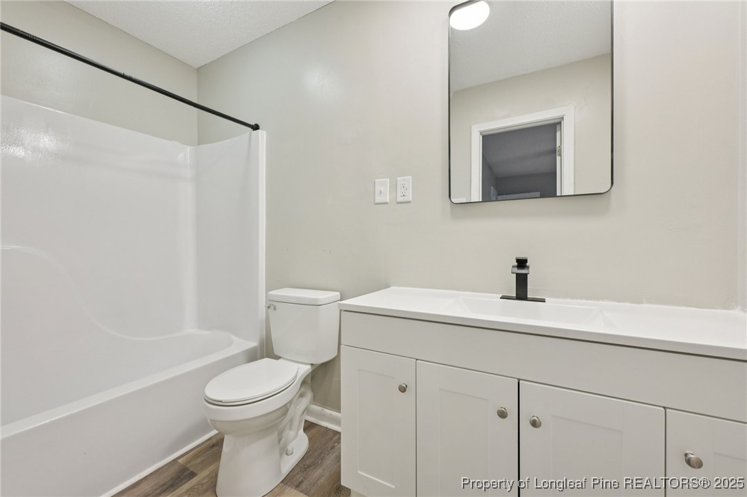 211 Lemuel Black Road Bunnlevel, NC 28323 - Photo 17 of 29 a bathroom with a toilet sink a mirror and vanity