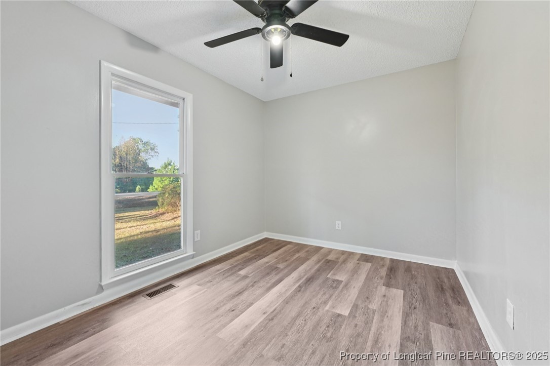 211 Lemuel Black Road Bunnlevel, NC 28323 - Photo 23 of 29 a view of wooden floor and chandelier fan in a room