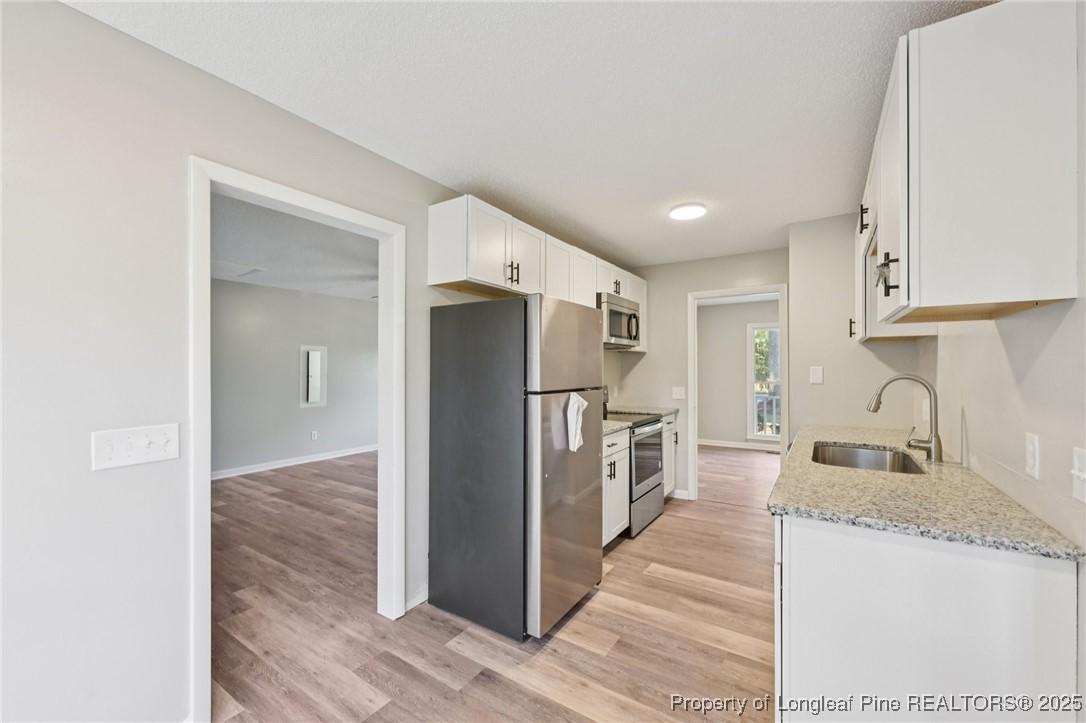 211 Lemuel Black Road Bunnlevel, NC 28323 - Photo 7 of 29 a kitchen with refrigerator and cabinets